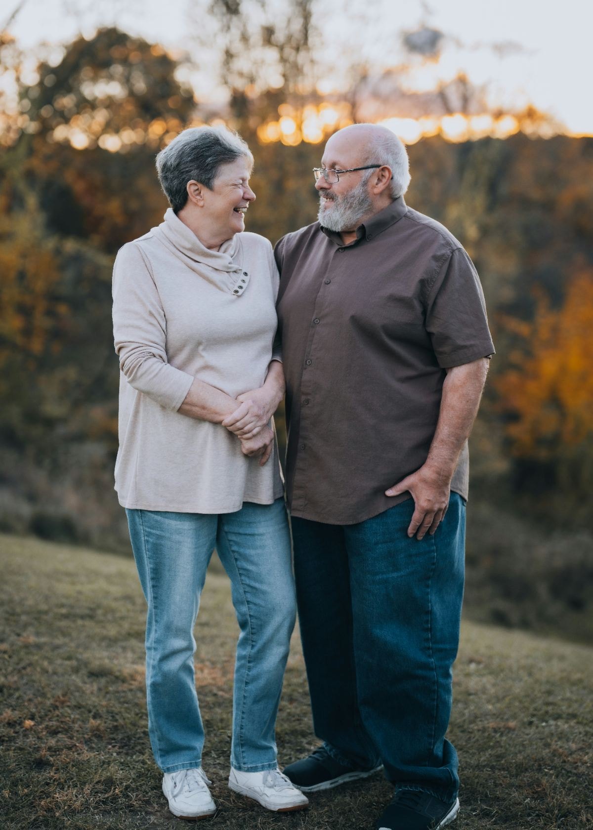 Older couple laughing together outdoors in autumn