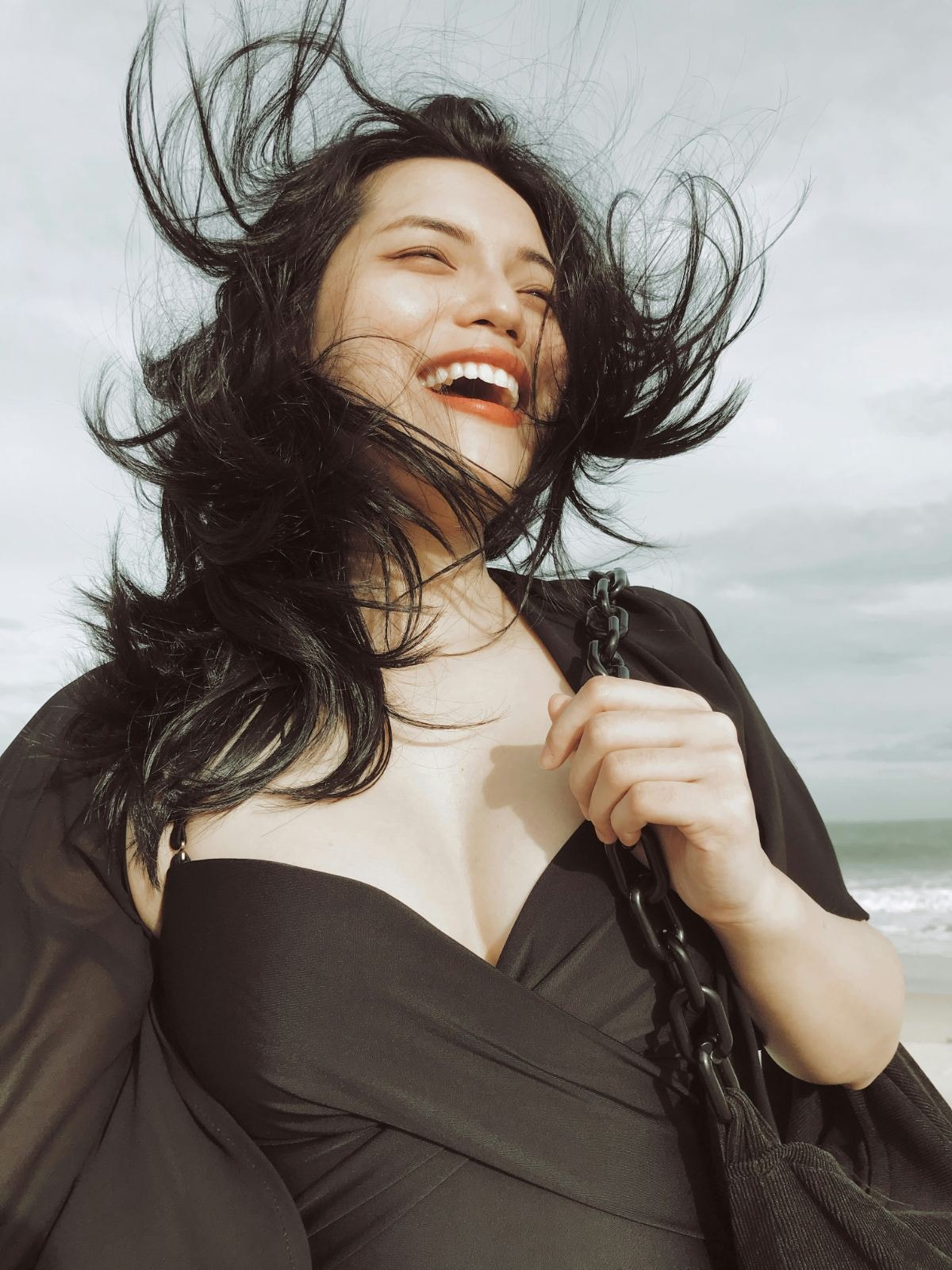 Laughing woman with hair blowing at the beach
