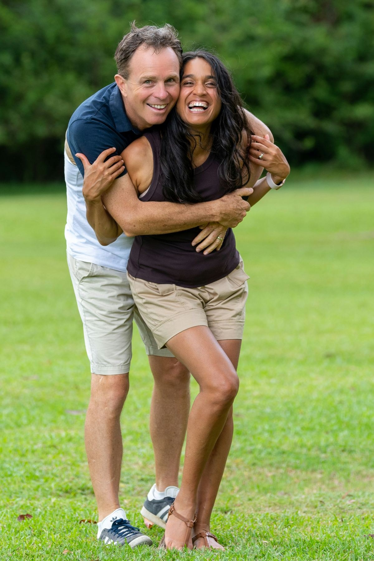 Laughing couple hugging in a park
