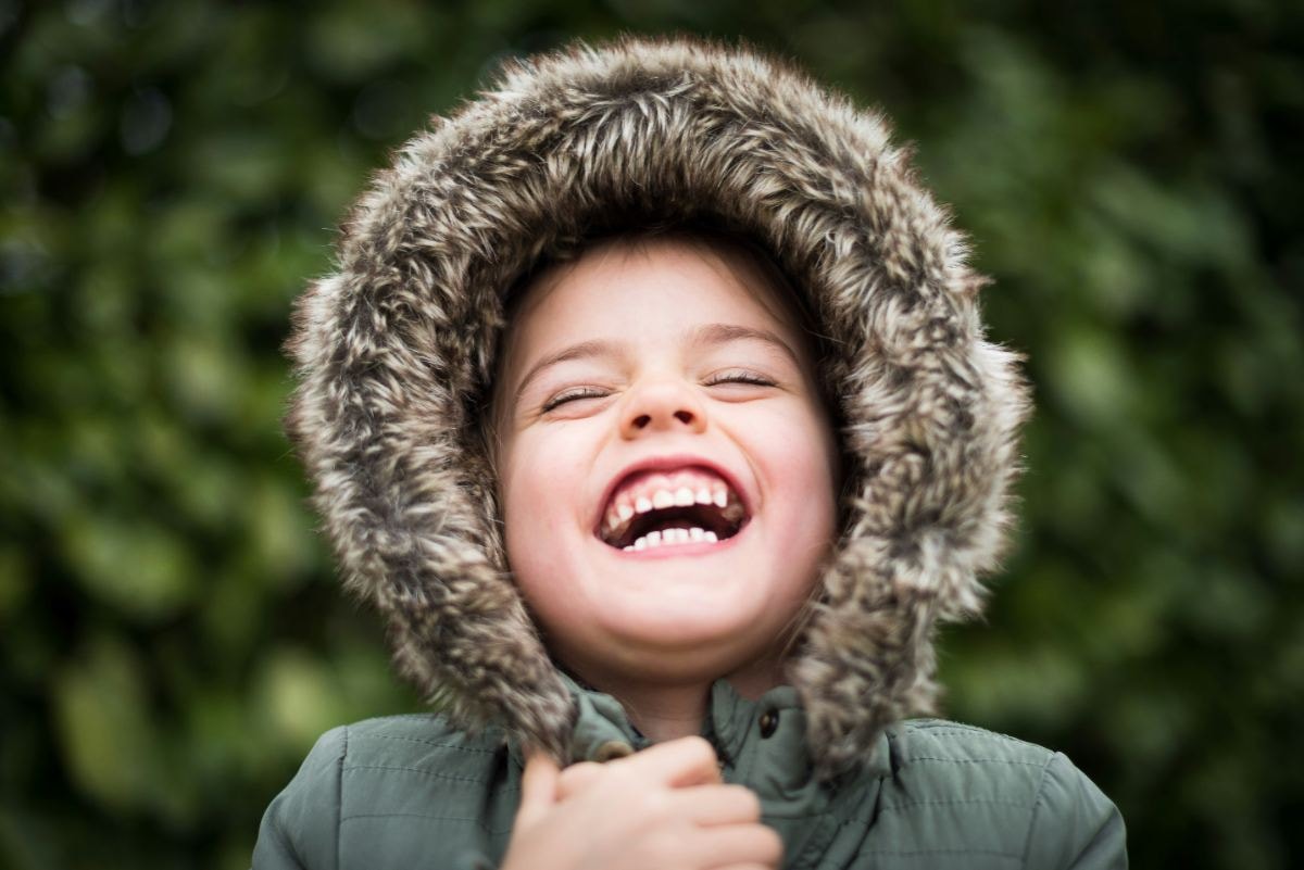 Laughing child in a fur-trimmed hood
